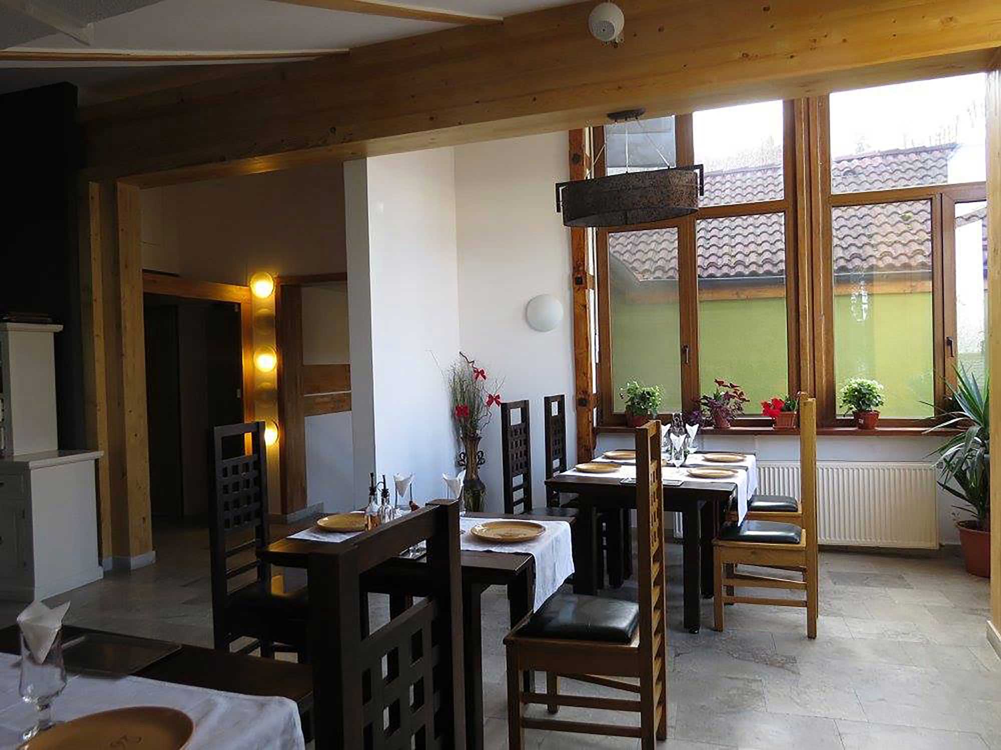 Bright dining room with large windows and plants